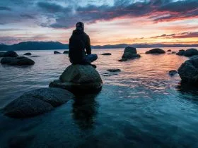 Persona meditando en la playa